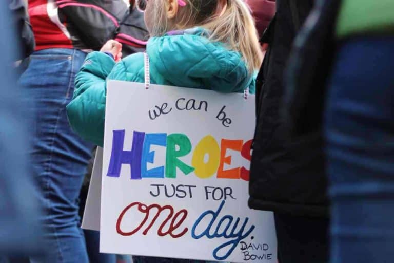 Kind trägt Schild auf dem rücken auf dem steht we can be heroes just for one da